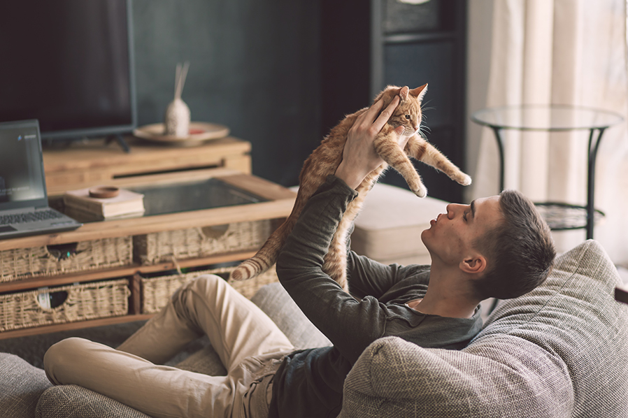 Imagen de un hombre con un gato en sus brazos.